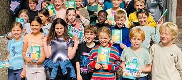 Die Schulkinder freuen sich gemeinsam mit ihren Klassenlehrerinnen sowie Laura Ziegler (Bildungsprojekt Möhrchenheft), Petra Coordes  (Prokuristin NAH.SH), Claus Ruhe Madsen (Verkehrsminister Schleswig-Holstein), Daniel Sebastian Syska (Schulleiter) und B Gruppenbild