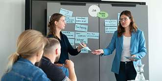 Bürosituation. Menschen stehen am Flipchart